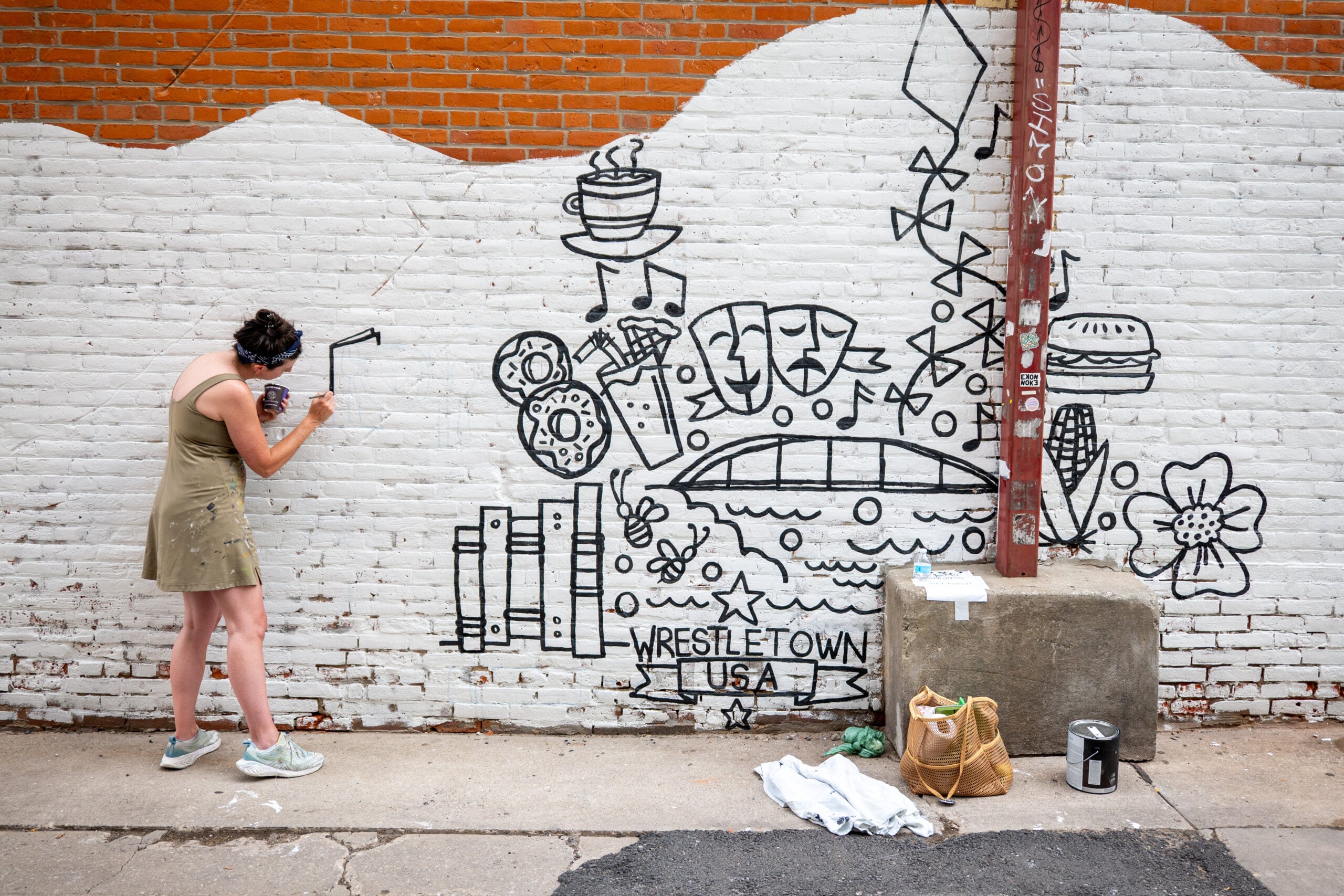 Laura Palmer paints and prepares the community Mural outside of MERGE in downtown Iowa City, Iowa.